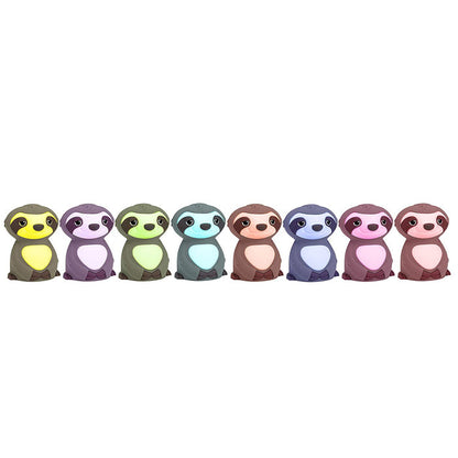 Eight cartoon sloths in pastel colors—yellow, green, mint, blue, brown, purple, pink, and maroon—sit smiling in a row. The Silicone Nightlight makes a playful and adorable addition to any child's room.